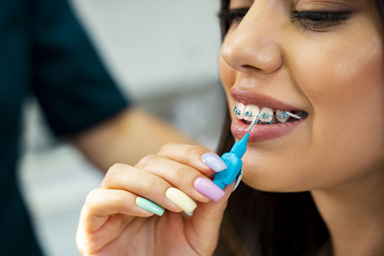 young woman learning how to use an interdental brush at the dentist