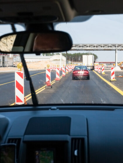 Car drives along construction zone area