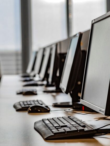row of computers sit on a desk