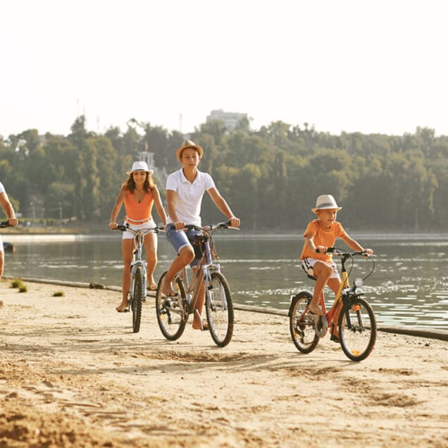 Family riding bicycles on embankment