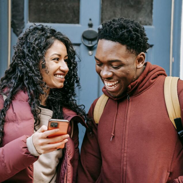 Cheerful couple watching on smartphone
