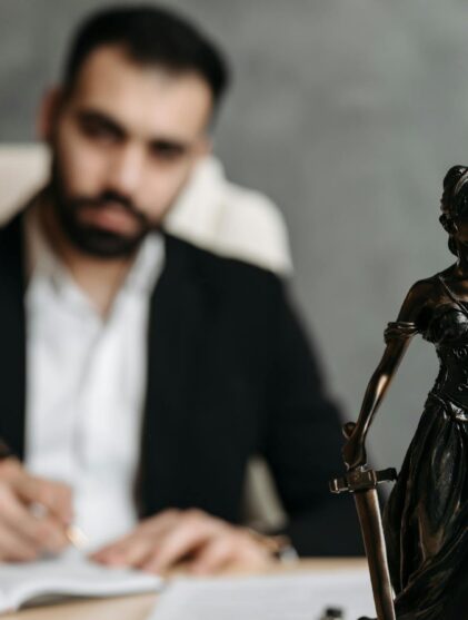 Man in black suit sitting on desk