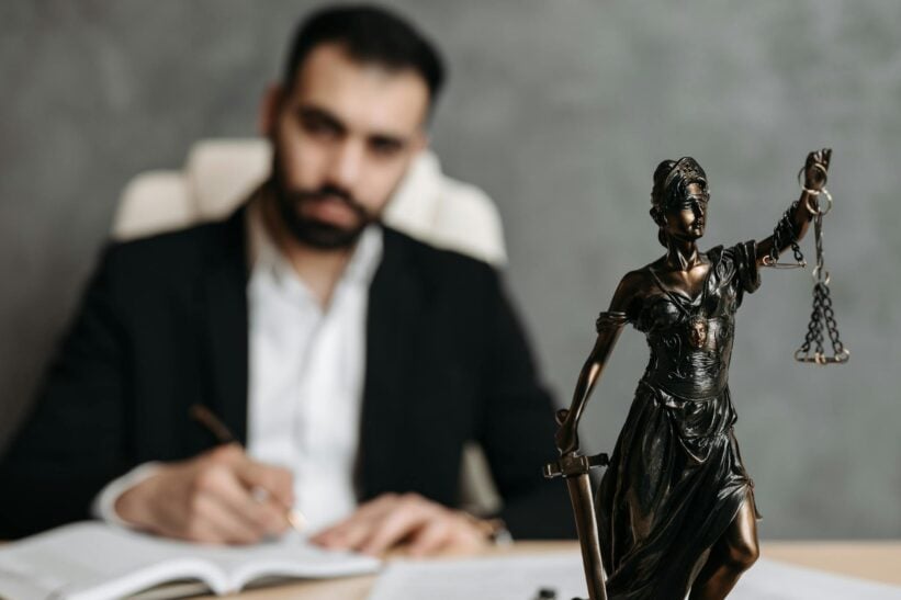 Man in black suit sitting on desk