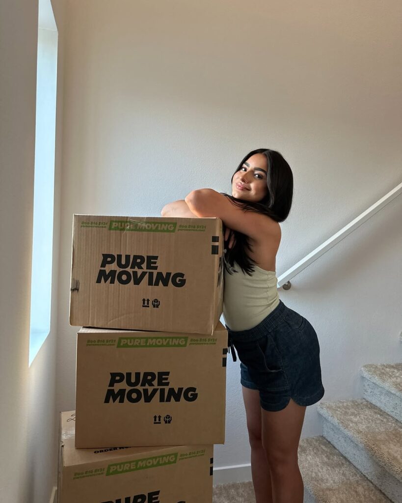woman posing beside stacked boxes