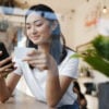 girl using her phone near a window