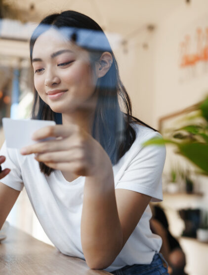girl using her phone near a window