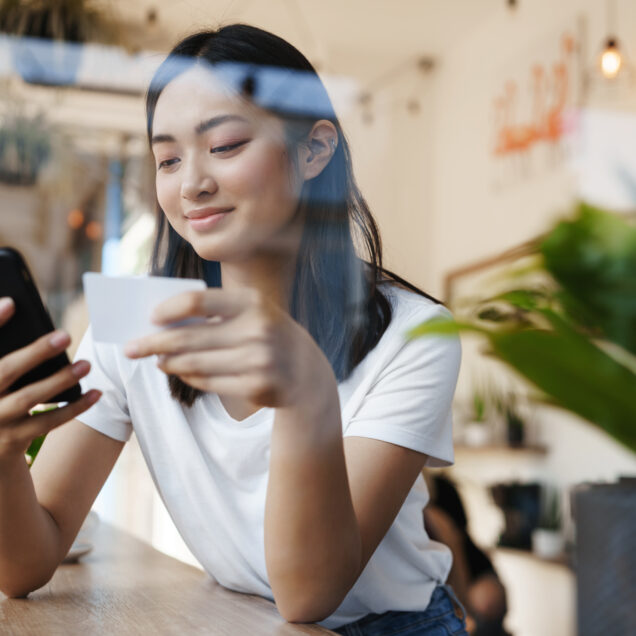 girl using her phone near a window