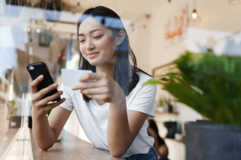 girl using her phone near a window