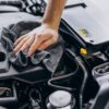 man wiping a car engine