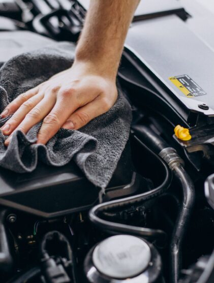 man wiping a car engine