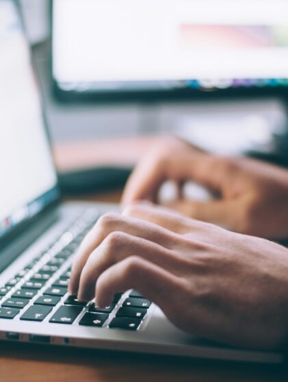 man typing on laptop