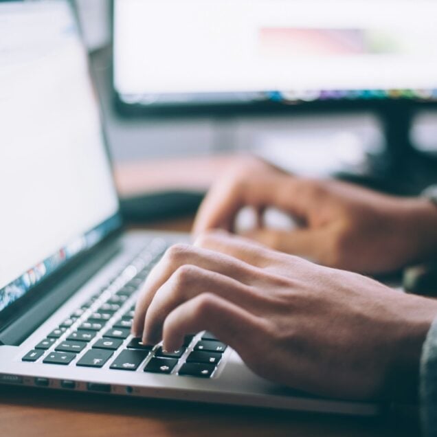man typing on laptop